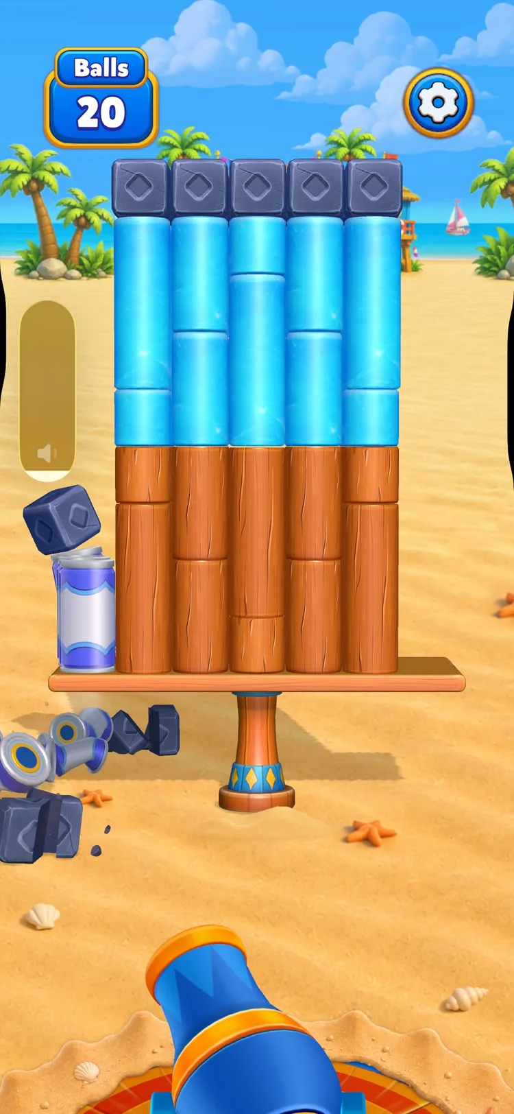 A taller Smash Fest structure — columns of ice blocks and wooden logs topped with stone cubes, with knocked-off pieces already scattered in the sand