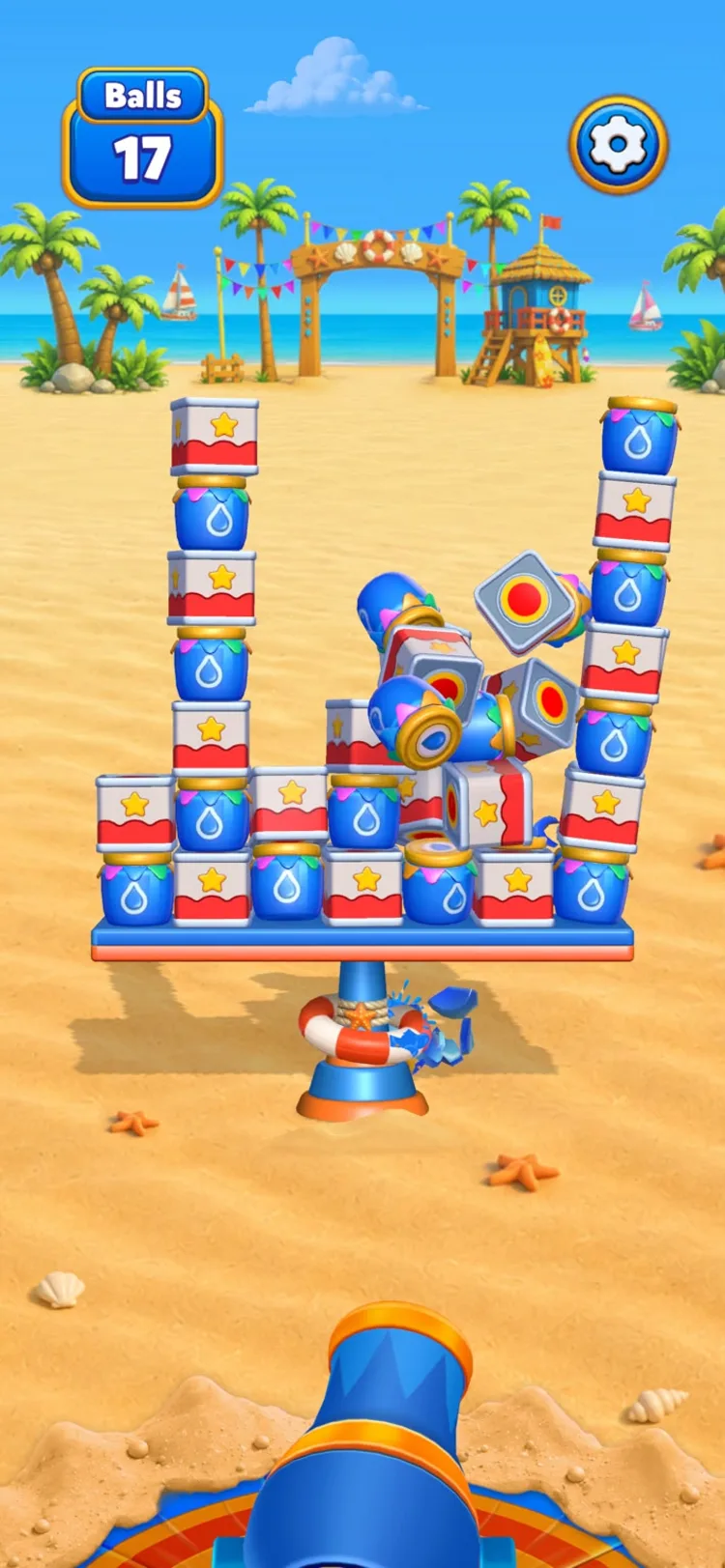Two towers of striped tins and water jars mid-topple, with cubes spinning through the air and a little crab scuttling past the platform base